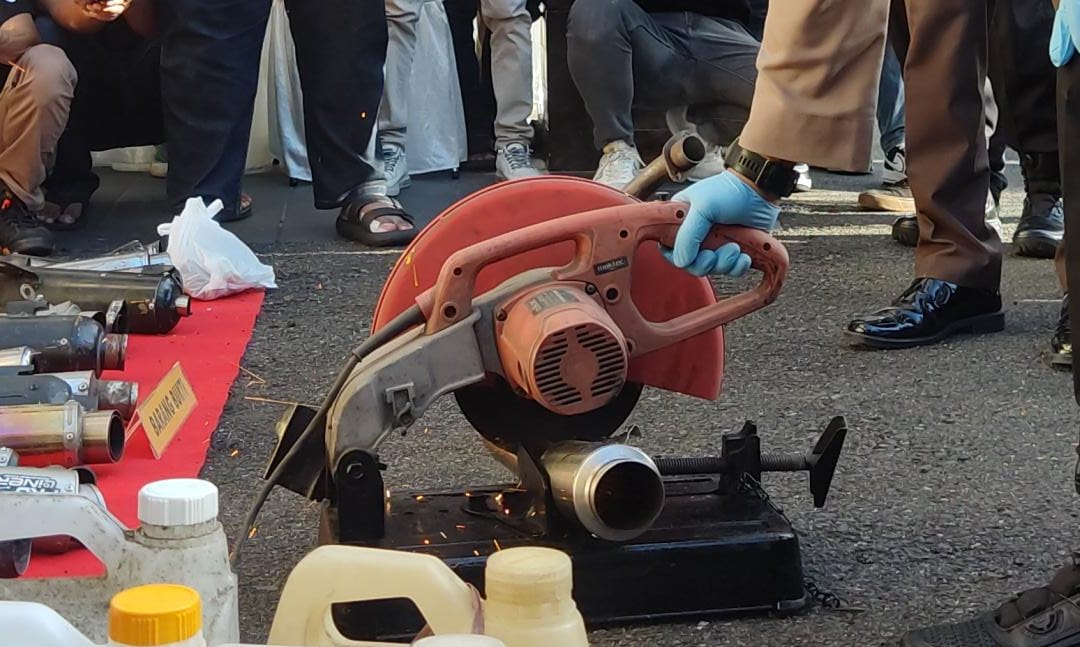 Knalpot brong dimusnahkan menggunakan alat pemotong.